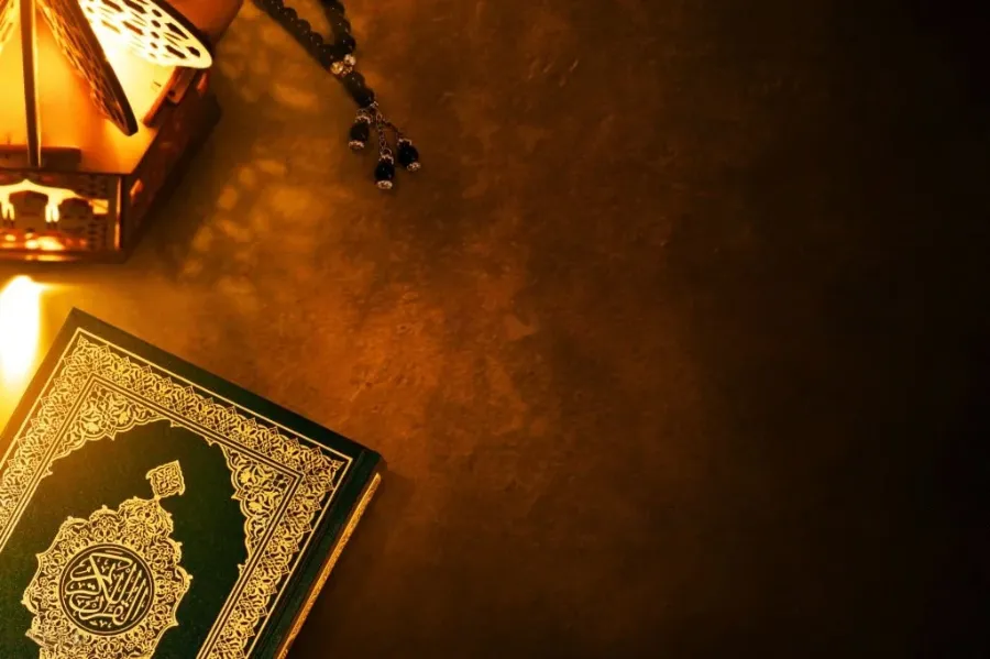 Open Mushaf of the Holy Quran with prayer beads and a lantern, for Quran memorization